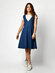 Fototapeta premium Young beautiful woman walking in new design casual summer jeans dress full body on grey 