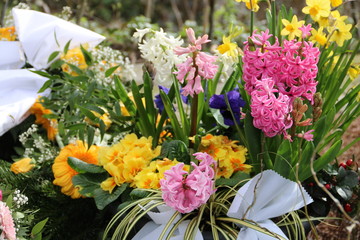 Blumen schmücken ein Grab im Frühling