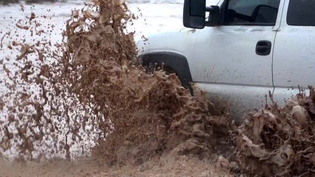 White truck mud bogging in a big puddle