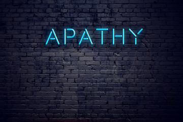 Brick wall and neon sign with text apathy - obrazy, fototapety, plakaty