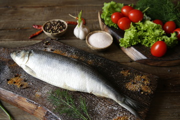 herring with vegetables and spices on a wooden rustic board