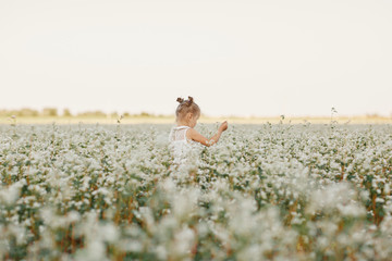 children's portrait of a girl. beautiful girl in a flowering field. Young girl play in spring...