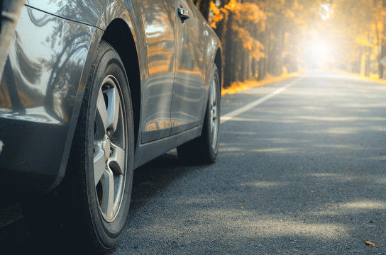 Closeup Car Tires Wheel Vehicle On Asphalt Road In Autumn Forest Leaves Fall Driving Trip Transportation To Travel In Nature Woods Holidays Travel Safety Adventure Countryside Vacation Relaxing.