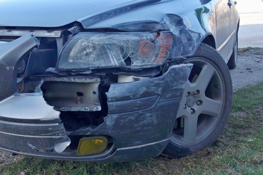 Car accident concept. Car crash, frontal collision, damaged front of blue car, broken light and fender.