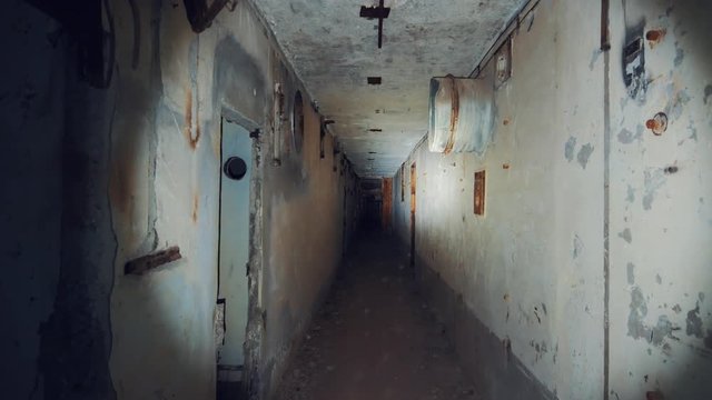 Moving through dark creepy corridor in abandoned nuclear power plant in Crimea. First person view, going with flashlight in dirty grunge tunnel in ruined building, horror escape concept