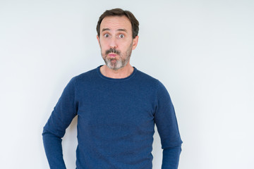 Fototapeta premium Elegant senior man over isolated background puffing cheeks with funny face. Mouth inflated with air, crazy expression.