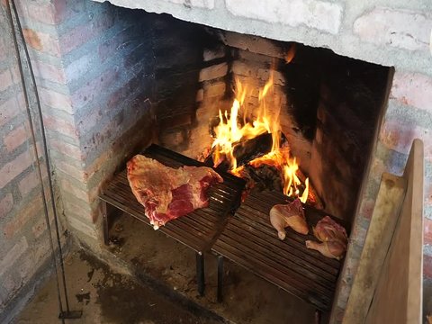 Cooking meat and chicken on a grill. Traditional Asado in Argentina