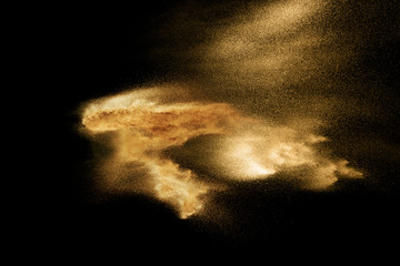 Fototapeta na wymiar Sand explosion isolated on black background. Freeze motion of sandy dust splashing.