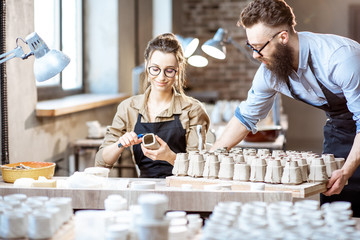 Man and woman working in the pottery shop