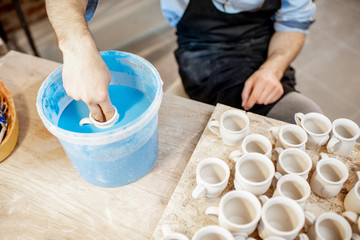 Painting clay jugs at the pottery