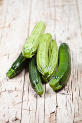 Fresh green zucchini on wooden rustic table.
