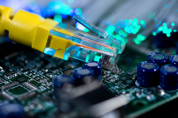 Yellow internet switch on computer circuit board , glowing optical fibres, image for background,...