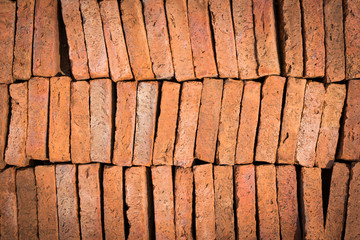 Red brick that is arranged in an orderly manner. Is a popular material used in construction. Showing textures and patterns. Suitable to be used as a background image and graphic design.