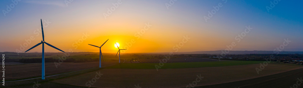 Wall mural Aerial view of a wind farm during a dramatic sunrise in the English countryside, England panoramic