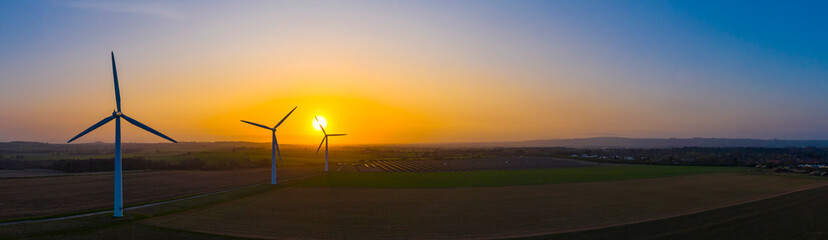 Aerial view of a wind farm during a dramatic sunrise in the English countryside, England panoramic