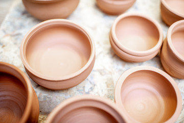 Close-up of clay pitchers before baking on the shelves at the pottery