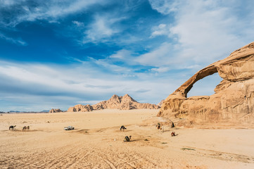 Bedouins with camels have a rest in incredible beautiful landscape in the Jordanian desert.