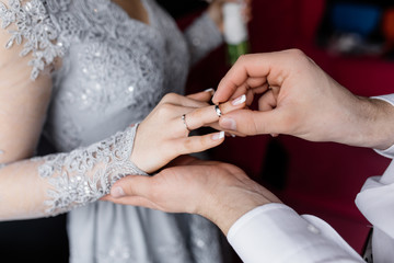 Obraz na płótnie Canvas The bridegroom wears a wedding ring for her beloved
