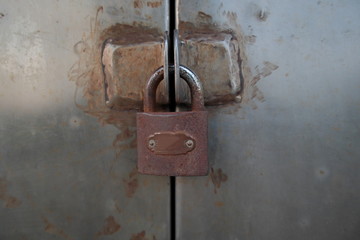 Rusty padlock lock the door.