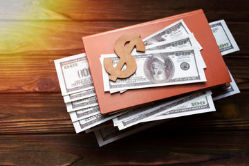 Dollars, a book on a wooden background. business, Finance, currency.