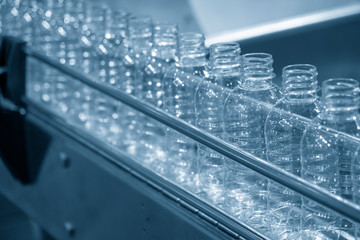 The plastic bottles on the conveyor belt at the drinking water factory. Drinking water manufacturing process.