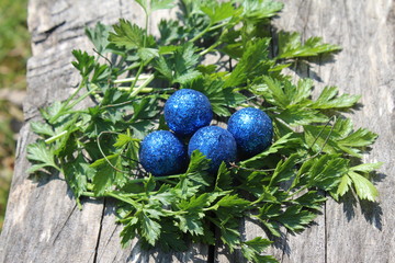 Obraz na płótnie Canvas Blue shiny Easter eggs in green herbs nest