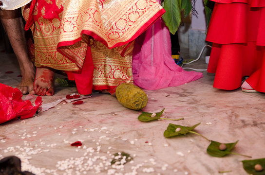 Indian wedding rituals, Gruha Pravesh / Gruhapravesh / Griha Pravesh, closeup picture of right feet of a Newly married Indian Hindu bride dipping her fit in a plate filled with liquid kumkum then step