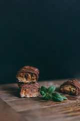 A bar on a wooden table on a black background with mint on the table