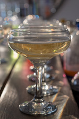 Glasses of champagne lined up on a bar. Bokeh in background.