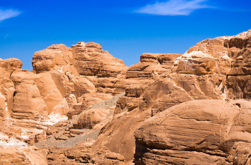 Fototapeta na wymiar peaks of high stone rocks against a blue sky in Egypt Dahab South Sinai