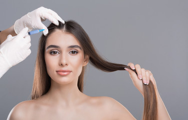 Woman getting cosmetics injection in head, free space