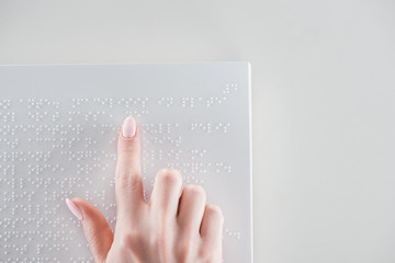 top view of young woman reading braille text on white paper with copy space - obrazy, fototapety, plakaty