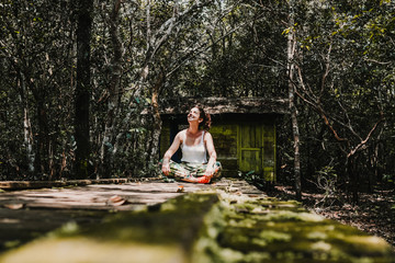 Fototapeta na wymiar .Young woman enjoying the forest jungle on the island of Borneo, Indonesia. Enjoying a moment of peace on a wooden path prepared to see wildlife of the rainforest. Travel Photography