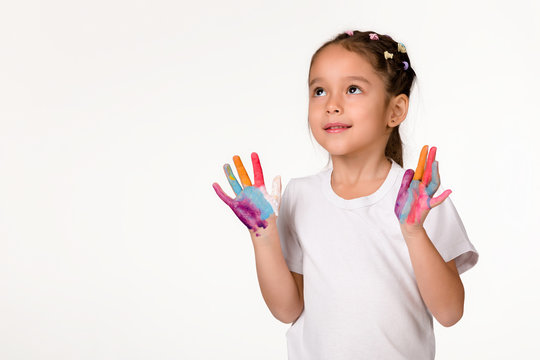 cute little child girl with hands painted in colorful paint isolated on white background.