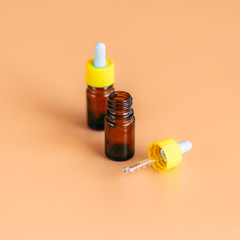 two glass dropper serum bottle on orange background with clipping path ready for cosmetic product design or medical for nose