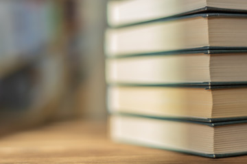 Book stack on the desk in the library room under sunrays