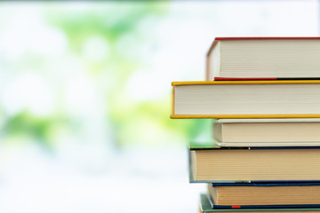 Multikolor book stack in the library room on tabel and blurred trees on street back to school concept