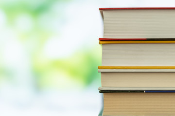 Book stack in the library room on tabel and blurred trees on street back to school concept