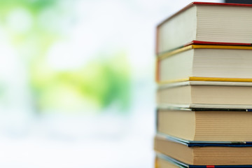 Book stack in the library room on tabel and blurred trees on street back to school concept