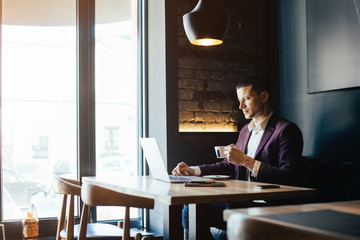 Young handsome businessman conducting negotiations with investors. Electronic business. Alternative...