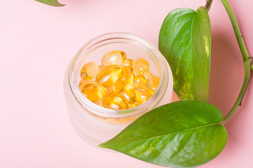 Fish oil capsules (omega-3) on a pink background
