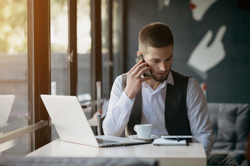 Naklejka premium Young man drawing template for the web site associated with digital marketing, current trends and tendencies of UX / UI design. Businessman who rules his company remotely, like a freelancer