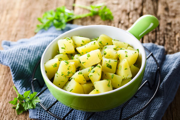 Fresh homemade boiled potatoes with parsley in bowl (Selective Focus, Focus in the middle of the image)