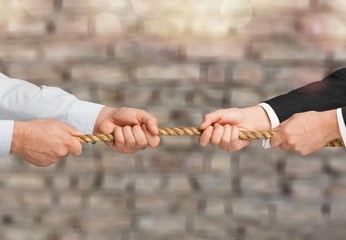 Tug war, two businessman pulling a rope in opposite directions isolated on white background