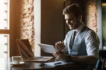 Young handsome businessman conducting negotiations with investors. Electronic business. Alternative...