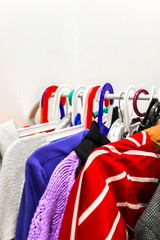 Colorful hangers with variety of clothes. Choice of textile