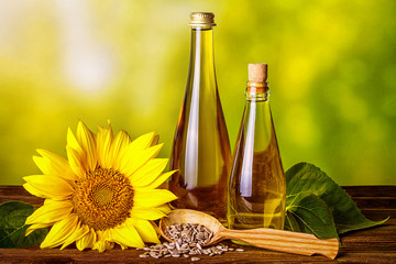 Rural still-life - sunflower oil in bottles with flowers of sunflower (Helianthus annuus), closeup