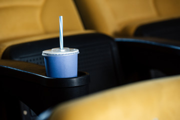 selective focus of cinema seat with blue disposable cup in cup holder