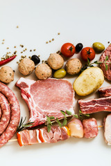 different types of raw meat: chicken thighs, pork and beef burgers, ribs and kebabs, turkey meatballs, ready to be cooked with potatoes, hot pepper, olives and black olives . Meat Food Background