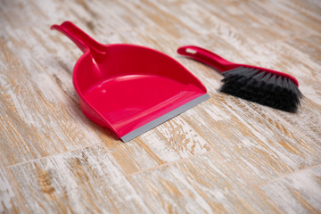 Broom and scoop on wooden background. Plastic equipment for cleaning